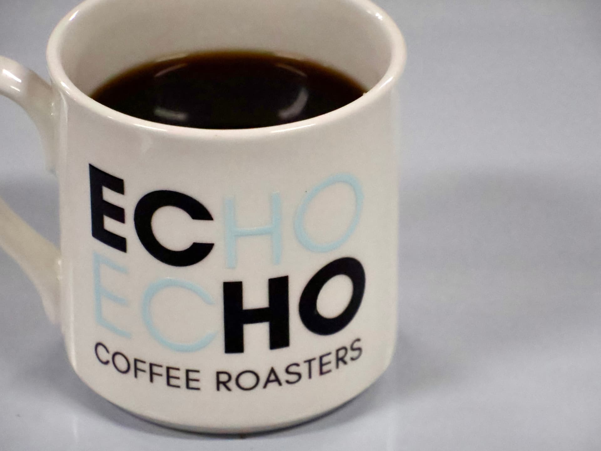A full ECHO mug of freshly brewed black coffee